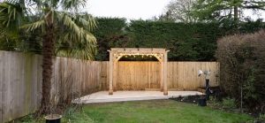 Solid oak pergola with trellis providing shade and support for climbing plants