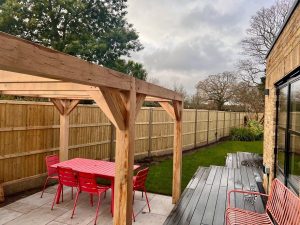 Contemporary oak pergola with a spacious design, ideal for outdoor dining and relaxation.