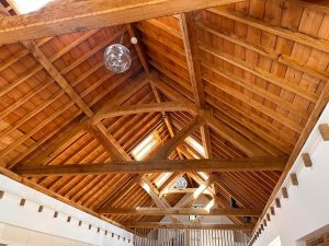 Green oak queen post truss structure featuring two vertical queen posts and a horizontal beam, showcasing its strength and stability