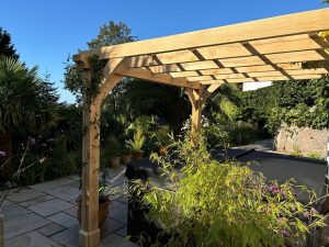 Custom oak lean-to pergola with optional lattice for climbing plants, attached to a house