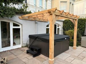 Bespoke oak lean-to pergola offering shade and outdoor elegance for a patio area.
