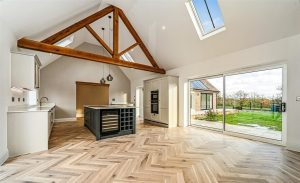 An oak fluted king post truss with intricate carved detailing for a refined aesthetic.