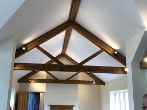 Interior view of a commercial building featuring oak queen post trusses that allow for wide spans and open areas
