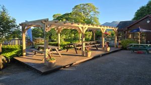 Large oak pergola with three bays, crafted from solid oak beams for durability and timeless garden style.
