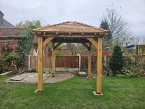 Compact 3 x 3 m oak gazebo with a solid wood frame, offering a shaded retreat in any garden setting.