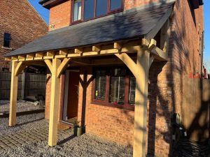 Oak lean-to gazebo with slate roof, offering a bespoke design and elegant shelter for outdoor spaces.