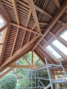 Bespoke oak gazebo with a gable roof and elegant lattice panels for climbing plants.